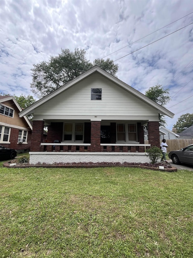 801 Spring St, Memphis, TN 38112 - bungalow-style home with covered porch, a front yard, and brick siding