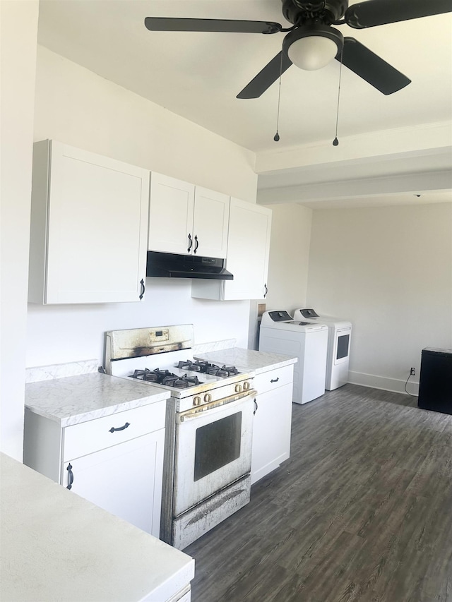 801 Spring St, Memphis, TN 38112 - kitchen featuring gas stove, washer and clothes dryer, under cabinet range hood, light countertops, and white cabinets