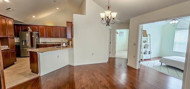 1601 E Southfield Cir, Memphis, TN 38016 - kitchen featuring stainless steel fridge with ice dispenser, a sink, a peninsula, high vaulted ceiling, and hanging light fixtures