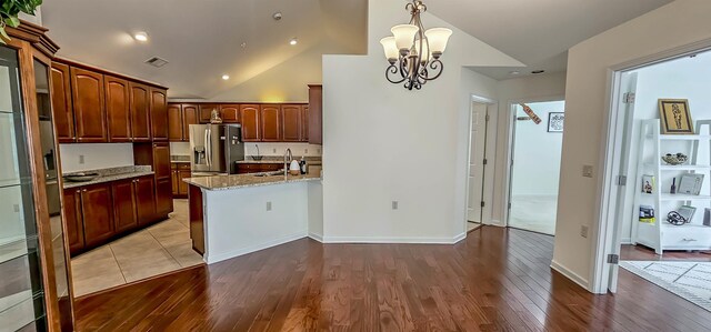 1601 E Southfield Cir, Memphis, TN 38016 - kitchen featuring stainless steel fridge with ice dispenser, a chandelier, a peninsula, wood finished floors, and lofted ceiling