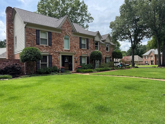 9290 E Bridge Dr, Germantown, TN 38139 - view of front of home with brick siding, a front yard, a chimney, and a shingled roof