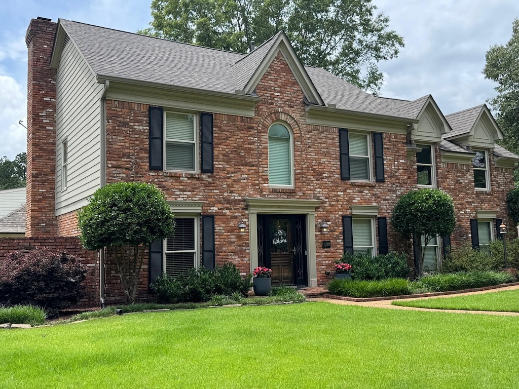 9290 E Bridge Dr, Germantown, TN 38139 - view of front of home featuring a chimney, a front yard, brick siding, and roof with shingles
