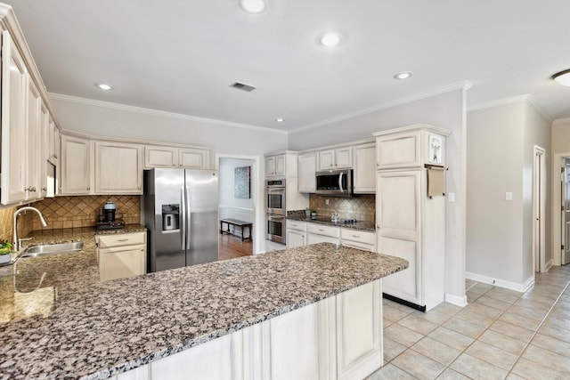 2045 Gallina Cir, Collierville, TN 38017 - kitchen with appliances with stainless steel finishes, a peninsula, tasteful backsplash, stone countertops, and recessed lighting