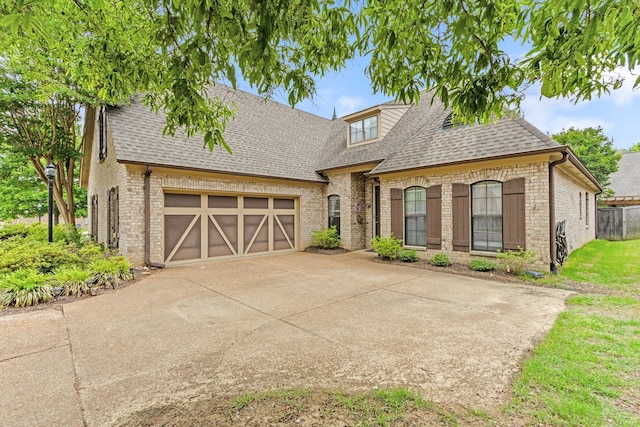 3190 Sea Ray Ln, Lakeland, TN 38002 - french country home with brick siding, a shingled roof, a garage, and driveway