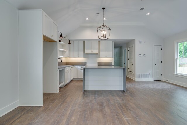 404 Williford Pl, Memphis, TN 38112 - kitchen featuring vaulted ceiling, a kitchen island, wood finished floors, baseboards, and white cabinets