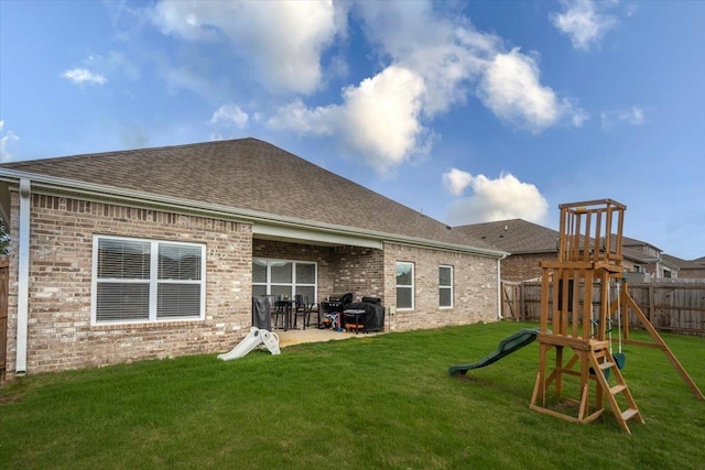 52 Twin Lakes Dr, Byhalia, MS 38611 - back of house featuring roof with shingles, brick siding, a patio area, and a playground