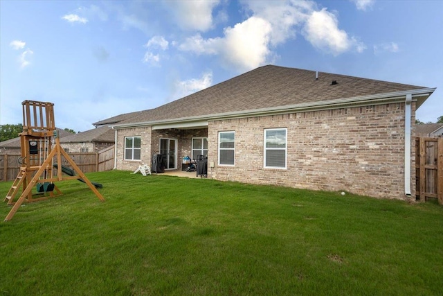 52 Twin Lakes Dr, Byhalia, MS 38611 - back of house featuring a playground, roof with shingles, brick siding, and a patio