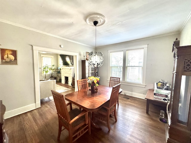 260 N Willett St, Memphis, TN 38112 - dining area featuring ornamental molding, dark wood finished floors, a chandelier, baseboards, and a stone fireplace