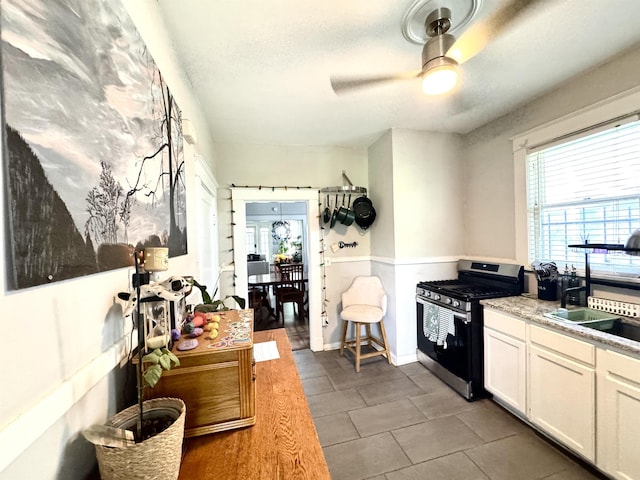 260 N Willett St, Memphis, TN 38112 - kitchen featuring stainless steel gas range, ceiling fan, white cabinets, tile patterned flooring, and light countertops