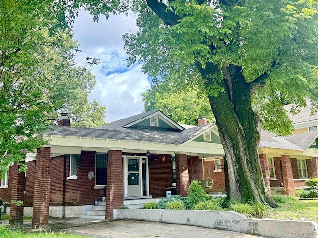 260 N Willett St, Memphis, TN 38112 - view of front of house with a chimney, brick siding, a shingled roof, and a porch