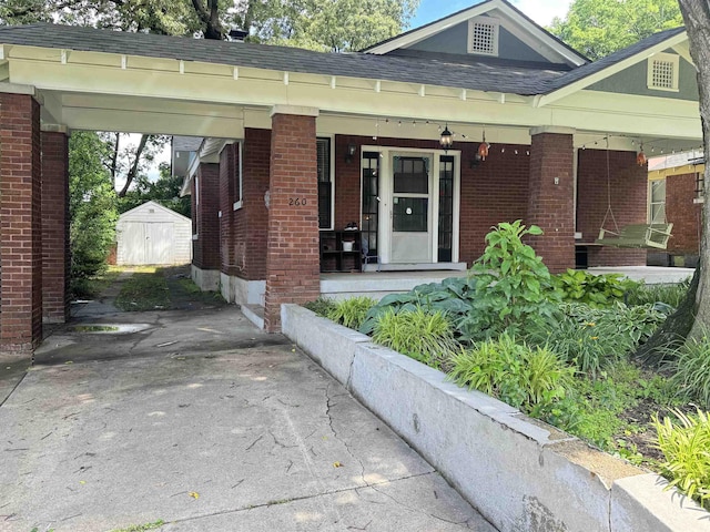260 N Willett St, Memphis, TN 38112 - view of front of house featuring brick siding, driveway, roof with shingles, and a porch