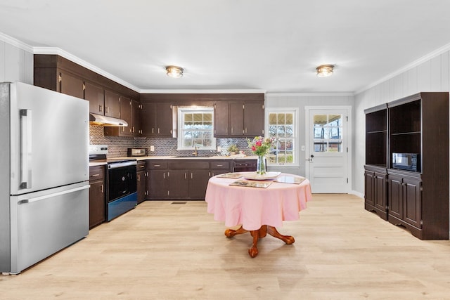 45 Daniel St, Savannah, TN 38372 - kitchen with appliances with stainless steel finishes, under cabinet range hood, dark brown cabinets, plenty of natural light, and crown molding