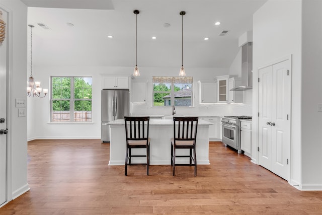 45 Laurel Hedge Cv, Oakland, TN 38060 - kitchen featuring appliances with stainless steel finishes, wall chimney range hood, a chandelier, light countertops, and white cabinetry