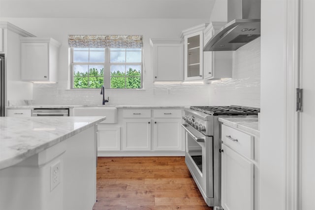 45 Laurel Hedge Cv, Oakland, TN 38060 - kitchen featuring wall chimney exhaust hood, stainless steel appliances, a sink, white cabinetry, and decorative backsplash