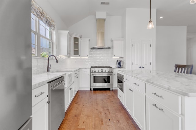 45 Laurel Hedge Cv, Oakland, TN 38060 - kitchen with appliances with stainless steel finishes, wall chimney exhaust hood, light stone counters, tasteful backsplash, and lofted ceiling