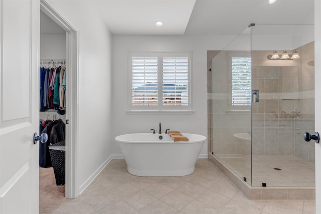 45 Laurel Hedge Cv, Oakland, TN 38060 - bathroom featuring a shower stall, a freestanding bath, baseboards, a walk in closet, and tile patterned flooring