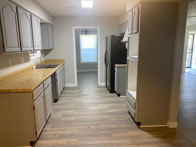 4947 Demeter Cv, Memphis, TN 38118 - kitchen featuring a sink, baseboards, plenty of natural light, and light wood-type flooring