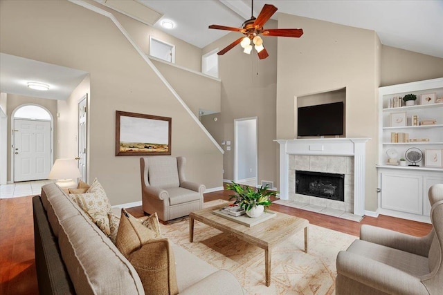9270 Durhamshire Dr, Cordova, TN 38016 - living room with ceiling fan, high vaulted ceiling, baseboards, a tile fireplace, and wood finished floors