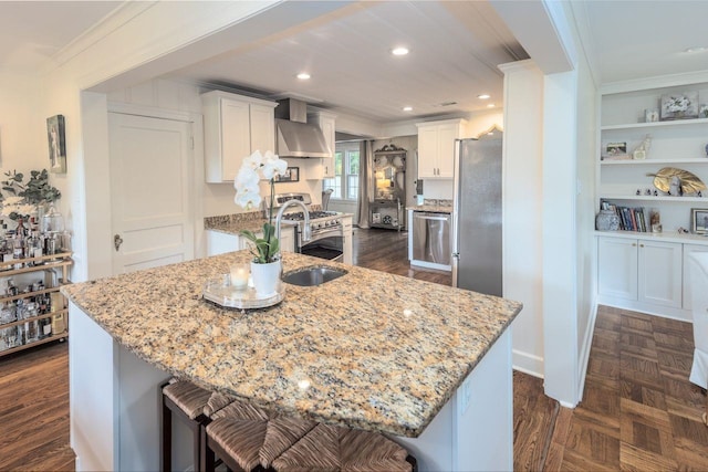 241 Greenway Rd, Memphis, TN 38117 - kitchen featuring wall chimney range hood, appliances with stainless steel finishes, ornamental molding, a sink, and white cabinets