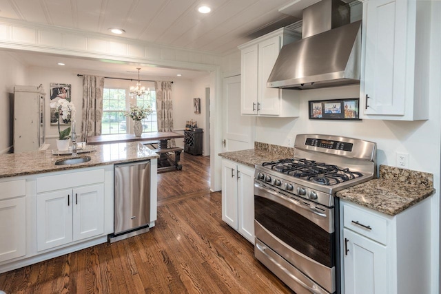 241 Greenway Rd, Memphis, TN 38117 - kitchen with stainless steel appliances, wall chimney exhaust hood, a chandelier, dark wood finished floors, and white cabinetry
