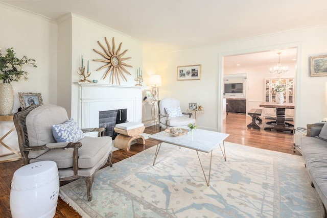 241 Greenway Rd, Memphis, TN 38117 - living room with wood finished floors, a chandelier, ornamental molding, a fireplace, and baseboards