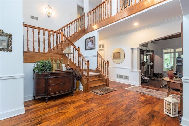 12821 Whispering Pines Dr, Olive Branch, MS 38654 - stairway with wood finished floors, baseboards, crown molding, and a towering ceiling