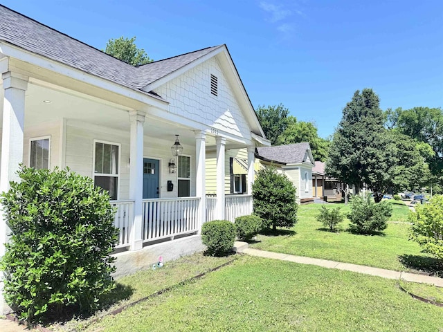 1742 Nelson Ave, Memphis, TN 38114 - view of property exterior featuring a porch, a shingled roof, and a lawn
