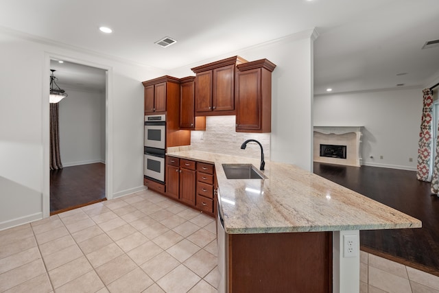 2073 W Houston Way, Collierville, TN 38139 - kitchen with a sink, stainless steel double oven, light tile patterned flooring, backsplash, and ornamental molding