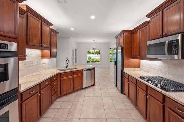2073 W Houston Way, Collierville, TN 38139 - kitchen featuring appliances with stainless steel finishes, light tile patterned flooring, a sink, a peninsula, and decorative backsplash