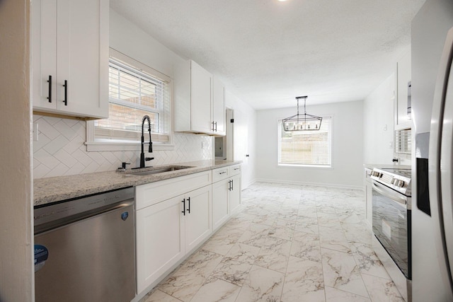5236 Marynelle Cv, Memphis, TN 38116 - kitchen featuring stainless steel appliances, a sink, light marble finish flooring, white cabinets, and decorative backsplash