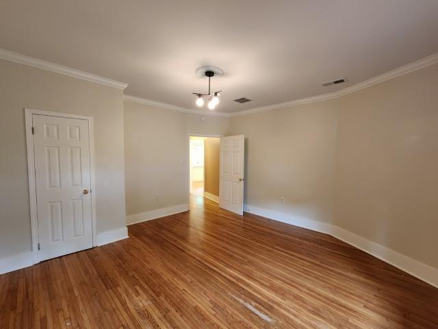 1466 Snowden Ave, Memphis, TN 38107 - spare room with crown molding, wood finished floors, and baseboards