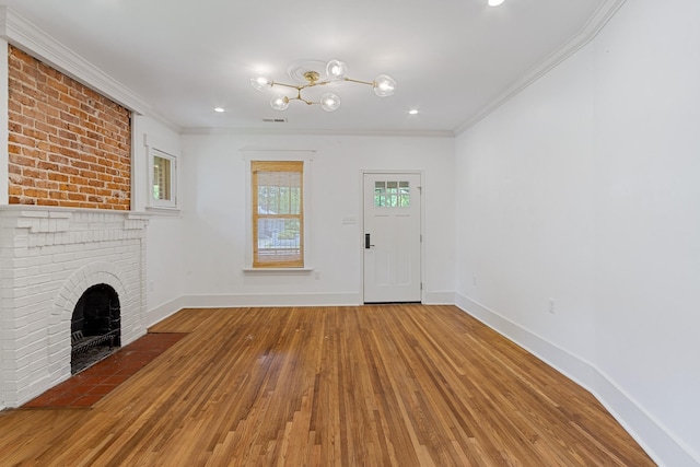 1466 Snowden Ave, Memphis, TN 38107 - unfurnished living room featuring hardwood / wood-style flooring, ornamental molding, a chandelier, baseboards, and a brick fireplace