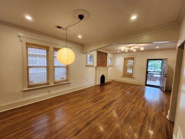 1466 Snowden Ave, Memphis, TN 38107 - unfurnished living room featuring crown molding, dark wood-style flooring, baseboards, a brick fireplace, and recessed lighting
