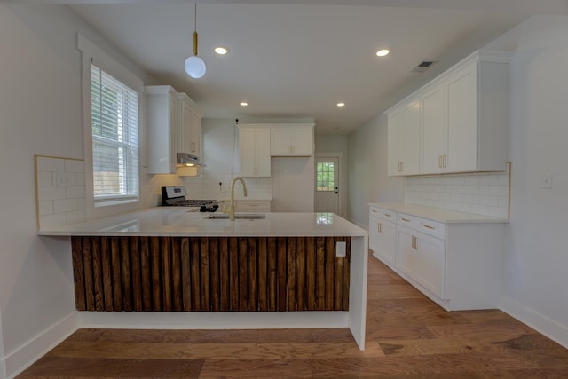 857 E Parkway St, Memphis, TN 38104 - kitchen featuring stainless steel range with gas stovetop, a peninsula, a sink, decorative backsplash, and recessed lighting
