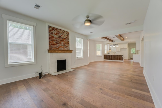 857 E Parkway St, Memphis, TN 38104 - unfurnished living room featuring a brick fireplace, ceiling fan, light wood-type flooring, and baseboards