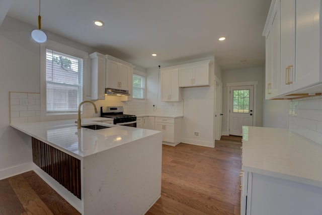 857 E Parkway St, Memphis, TN 38104 - kitchen with a sink, stainless steel gas range, under cabinet range hood, a peninsula, and decorative backsplash
