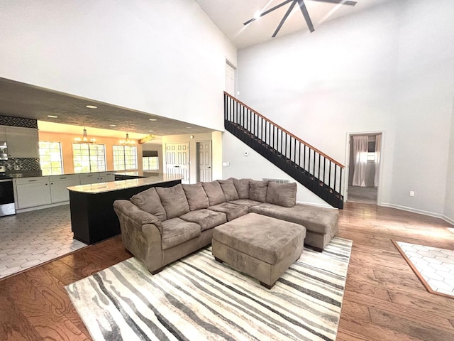 245 Holiday Hills Ln, Counce, TN 38326 - living room with a towering ceiling, a chandelier, wood finished floors, stairs, and baseboards