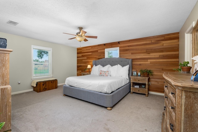 4072 Soderlund Cv, Millington, TN 38053 - bedroom featuring wood walls, multiple windows, light carpet, a ceiling fan, and a textured ceiling