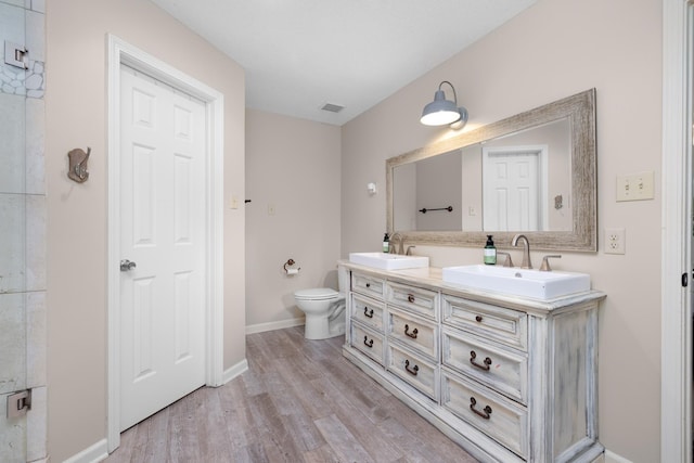 4072 Soderlund Cv, Millington, TN 38053 - full bath with double vanity, wood finished floors, toilet, and baseboards