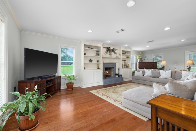 4072 Soderlund Cv, Millington, TN 38053 - living area featuring wood finished floors, ornamental molding, recessed lighting, a brick fireplace, and baseboards
