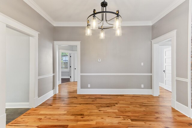 1906 Vollintine Ave, Memphis, TN 38107 - unfurnished dining area with a chandelier, ornamental molding, wood finished floors, and baseboards