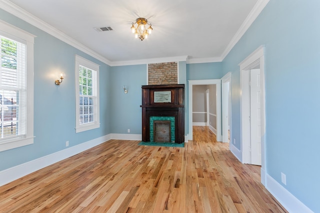 1906 Vollintine Ave, Memphis, TN 38107 - unfurnished living room featuring a fireplace, light wood-type flooring, ornamental molding, baseboards, and a chandelier