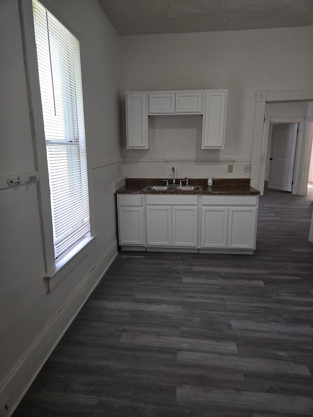 961 Joseph Pl, Memphis, TN 38107 - kitchen with a sink, white cabinets, dark countertops, baseboards, and dark wood finished floors