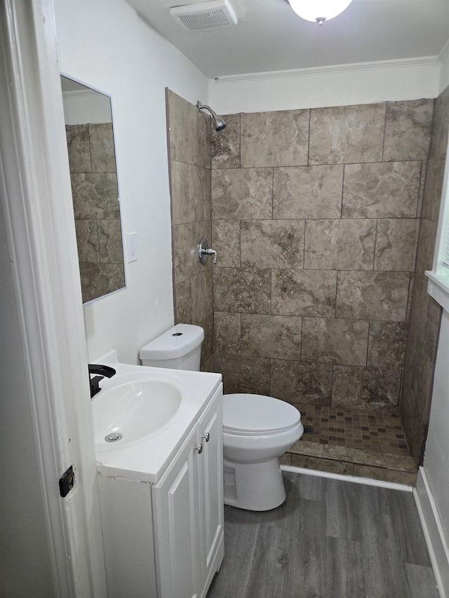 961 Joseph Pl, Memphis, TN 38107 - bathroom featuring wood finished floors, tiled shower, vanity, and toilet