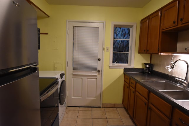 3007 Walnut Grove Rd Unit 1, Memphis, TN 38111 - kitchen with freestanding refrigerator, stove, independent washer and dryer, light tile patterned floors, and a sink