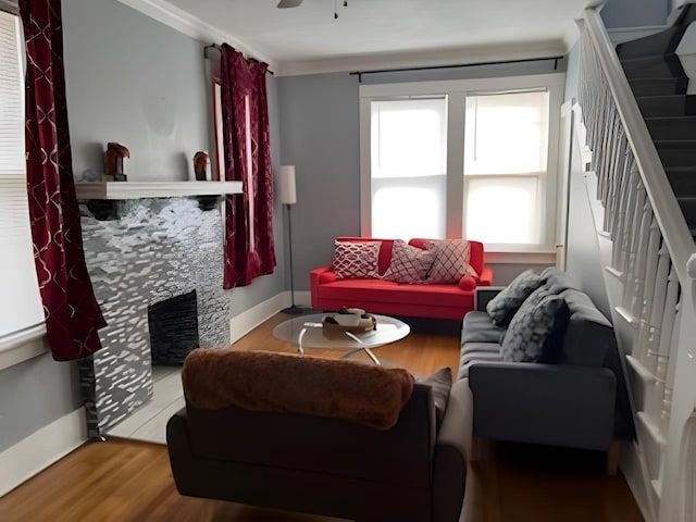 929 N Watkins St, Memphis, TN 38107 - living room featuring a fireplace, wood finished floors, stairway, and baseboards