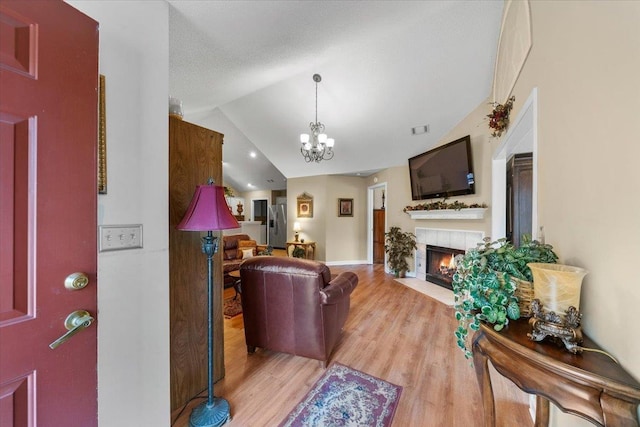 1961 Appling Oaks Cir Unit 29, Cordova, TN 38016 - living room with a fireplace, lofted ceiling, a chandelier, and light wood-style floors