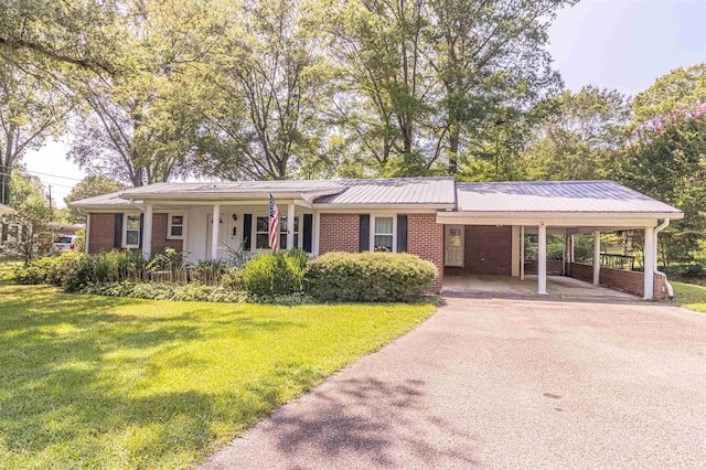 48 Baker Rd, Selmer, TN 38375 - single story home featuring driveway, a front lawn, brick siding, a carport, and metal roof