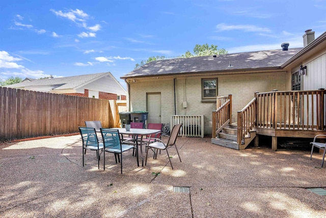 4951 Lynbar Ave, Memphis, TN 38117 - rear view of house featuring brick siding, a wooden deck, outdoor dining area, and a patio