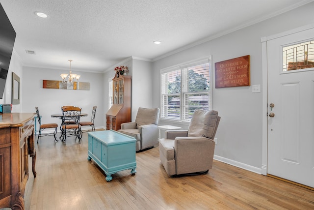 4951 Lynbar Ave, Memphis, TN 38117 - living area with a chandelier, light wood-type flooring, a textured ceiling, baseboards, and ornamental molding